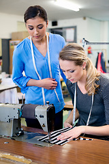 Image showing Sewing, machine and woman in training workshop, learning to work with fabric and process in fashion. Tailor, mentoring or help manufacturing clothes in small business with teamwork in factory