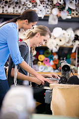 Image showing Sewing, machine and training woman in workshop, learning to work with fabric and process in fashion. Tailor, mentoring or help manufacturing clothes in small business with teamwork in factory