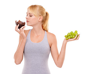 Image showing Woman, temptation and dessert over fruit in studio with white background in backdrop. Girl, choice and decision between muffin or grapes for nutrition in food, think and care for wellness of body