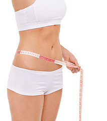 Image showing Woman, stomach and measure in studio for weight loss, tape and fitness for health. Female person, results on progress and nutrition for slim body, abdomen and workout isolated with white background