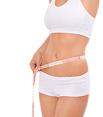 Image showing Woman, abdomen and tape in studio for health, measuring and fitness for weight loss. Female person, results on progress and nutrition for slim body, stomach and workout closeup with white background