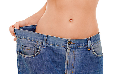 Image showing Diet, body and woman with big pants in studio for weight loss, fitness or exercise results. Wellness, health and closeup of female person with jeans for measuring slim stomach by white background.