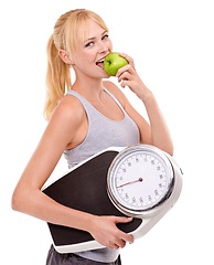 Image showing Portrait, scale and woman with apple for progress, diet benefits or food to lose weight in studio. Healthy eating, nutrition and happy girl with fruit for weightloss, digestion and white background