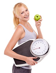 Image showing Portrait, scale and happy woman with apple for diet, benefits or food to lose weight in studio. Healthy eating, nutrition and girl with fruit for weightloss, digestion and smile on white background.