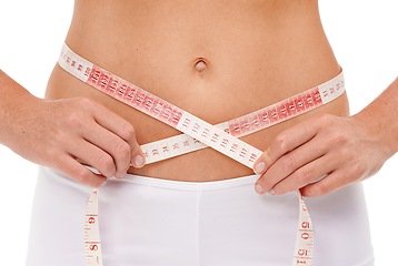 Image showing Woman, stomach and weight loss with tape measure, fitness and studio for workout and body care with wellness. Female person, health and white background for diet, lifestyle and natural in underwear