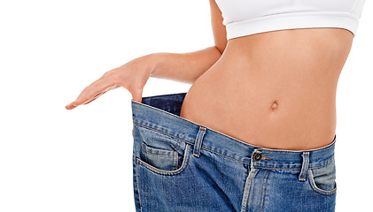 Image showing Body, health and woman with big pants in studio for weight loss, fitness or exercise results. Wellness, diet and closeup of female person with jeans for measuring slim stomach by white background.