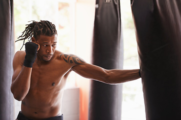 Image showing Fitness, body and punch with black man kickboxing in gym for health, power or combat sports training. Exercise, mma or self defense and young shirtless fighter with punching bag for strength workout