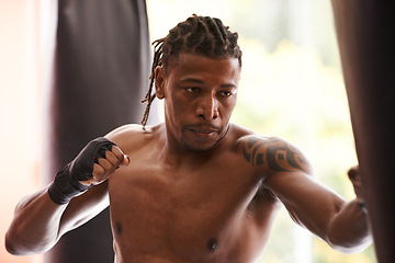 Image showing Fitness, punching bag and serious black man in gym for exercise, boxing challenge or competition training. Power, muscle and champion boxer at workout with confidence, fight and energy in sports club