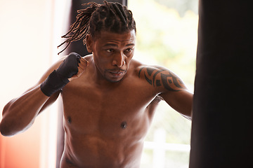 Image showing Fitness, punching bag and black man in gym for fight, exercise or boxing competition training. Power, muscle and serious champion boxer at workout with confidence, challenge and energy in sports club