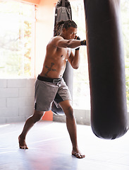 Image showing Fitness, punching bag and black man in gym for body exercise, boxing challenge or competition training. Power, muscle and champion boxer at workout with confidence, fight and energy in sports club.