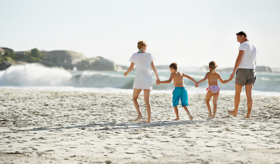 Image showing Parents, children and hand holding on beach for travel together at ocean for trip connection, bonding or love. Man, woman and siblings with back view at sea in Florida for vacation, outdoor or family