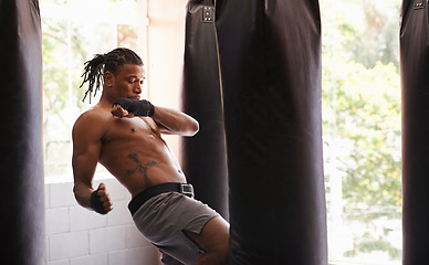 Image showing Exercise, body and knee with black man kickboxing in gym for health, power or combat sports training. Fitness, club or self defense and young shirtless fighter with punching bag for strength workout