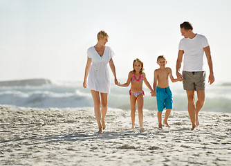 Image showing Parents, children and hand holding on beach for love connection with tropical travel, holiday or outdoor. Man, woman and siblings or walking on sand in Florida for vacation relax, seaside or family