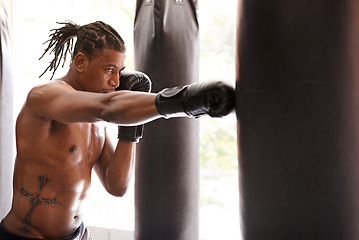 Image showing Muscle, punching bag and black man in gym for exercise, boxing challenge or competition training. Power, fitness and serious champion boxer at workout with confidence, fight and energy in sports club