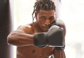 Image showing Power, portrait and black man with boxing gloves in gym for challenge, fight and competition training. Fitness, muscle and serious face of champion boxer at workout with confidence in sports club.