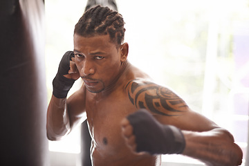 Image showing Boxing, portrait and black man with punch in gym for fitness challenge, fight and competition training. Power, muscle and serious face of champion boxer at workout with confidence in sports club.