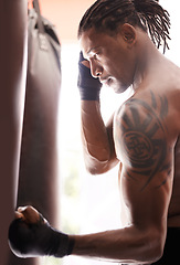 Image showing Exercise, body and punch with black man kickboxing in gym for health, power or combat sports training. Fitness, mma or martial arts and young shirtless fighter with punching bag for strength workout