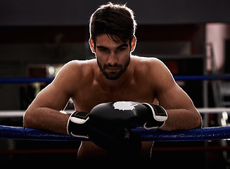 Image showing Portrait, gloves and man in serious boxing ring for exercise, challenge or competition fight in dark gym. Power, muscle or champion boxer at workout with confidence, pride or fitness in sports battle