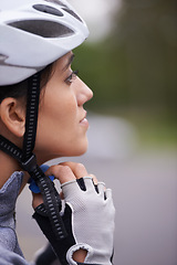 Image showing Cycling, woman and adjust helmet for safety, protection and exercise gear to travel outdoor. Bicyclist, person and putting on hat in preparation for training, sports or closeup for fitness in profile