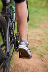 Image showing Cycling, legs and person on fast bicycle outdoor for exercise, workout or fitness for sports. Mountain bIke, speed and shoes of bicyclist in nature to travel on transport, journey or closeup of back