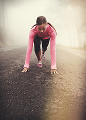 Image showing Runner, start and woman on path outdoor in forest, park or woods for exercise in winter. Morning, fog and person with fitness challenge or prepare for workout on road in countryside with nature