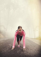 Image showing Runner, start and woman ready outdoor in forest, park or woods for exercise in winter. Morning, fog and person with fitness challenge or training in workout on road in countryside with nature