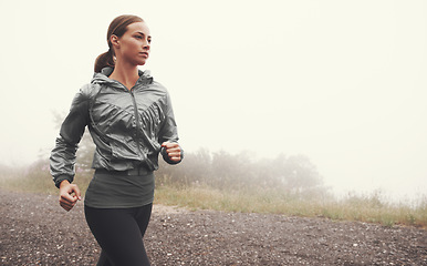 Image showing Fog, fitness and woman running on road outdoor for healthy body, wellness and training for sports on mockup space in winter. Mist, exercise and person workout for cardio, race and energy in nature