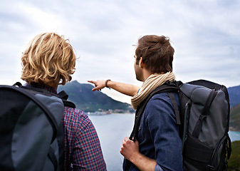 Image showing Man, friends and backpack for hiking by ocean in travel, sightseeing or outdoor journey in nature. Rear view of male person or hikers with bag on back for trekking, fitness or adventure by cloudy sky