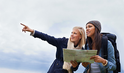 Image showing Woman, friends and pointing with map for direction or location on hiking adventure together in nature. Young female person, hiker or team with travel guide for destination, route or outdoor path