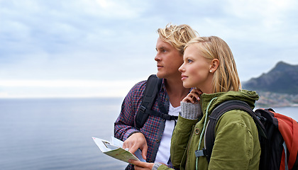 Image showing Couple, thinking and map by ocean for hiking, direction or location on outdoor adventure together in nature. Young man and woman reading tour or travel guide for route, path or destination on hike