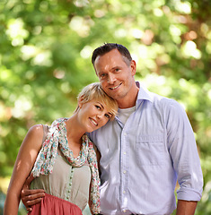 Image showing Love, portrait and happy couple hug in a park for travel, adventure or bonding in nature together. Face, romance or people embrace in forest for summer date, reunion or weekend, holiday or vacation