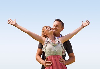 Image showing Couple, hug and smile with love outdoors for honeymoon vacation, together and arms up for freedom. Man, woman and relationship with care for romance, marriage and support with trust for happiness