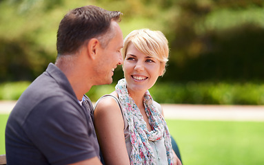 Image showing Happy, love and couple in a park with conversation, chat or romantic bonding in nature together. Smile, trust and people in a forest for travel, vacation or holiday, trip or date outdoor with support