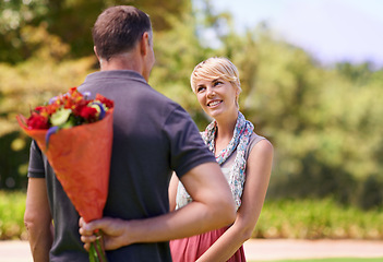 Image showing Surprise, happy couple and gift of flowers outdoor in nature, bonding or date on valentines day. Bouquet, man and woman with present for love, care or romantic connection of people at garden together