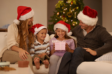 Image showing Family, living room and christmas with gift, excitement and joy with home on sofa. Parents, children and celebration with present, gratitude and thank you with happiness or appreciation for holiday