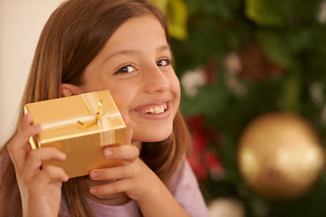 Image showing Christmas, tree and portrait of child with gift, smile and celebration with happy surprise in home. Holiday, festive and girl with present giving, xmas fun and excited in living room with mockup