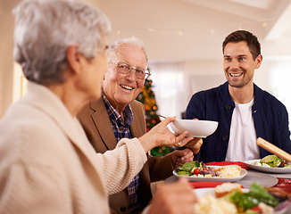 Image showing Senior, father and happy with family at Christmas dinner with food and reunion celebration in home. Holiday, event and man smile with lunch, roast dish and relax at dining room table with elderly