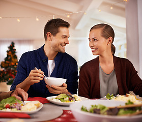 Image showing Christmas, happy couple and eating dinner in house, smile or bonding together at party. Xmas, man or woman at table for food at festive celebration, relax or hungry with salad for meal in home