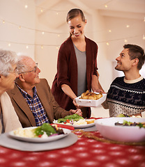Image showing Christmas, dinner and family smile at table together with food and celebration in home. Senior, mother and father with happiness at lunch with woman hosting holiday with dish of chicken on plate