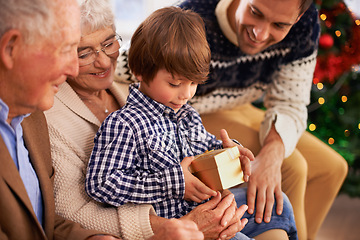 Image showing Father, grandparents and child with Christmas gift for festive season celebration for vacation, package or together. Kid, box and happy family in Canada for traditional holiday, bonding or opening