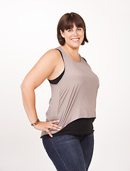 Image showing Studio, portrait and plus size woman with confidence for casual fashion to relax in jeans for comfort. Female person, smile and positive with happiness as model in white background of backdrop