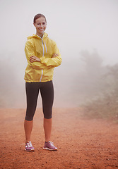 Image showing Woman, portrait and arms crossed for fitness in forest with fog for exercise, morning routine and workout with smile. Athlete, face and person or happy on outdoor trail for wellness and healthy body