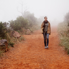 Image showing Winter, hiking and woman walking in nature for travel, wellness or morning break outdoor. Path, trekking and calm female person in a forest for fresh air, holiday or adventure, journey or discovery