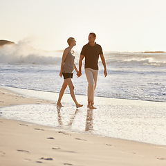 Image showing Couple, walking and beach at sunset for romantic date, weekend getaway or honeymoon in Indonesia. Happy woman, man or people in love with smile for holding hands, bonding and rest and relaxation