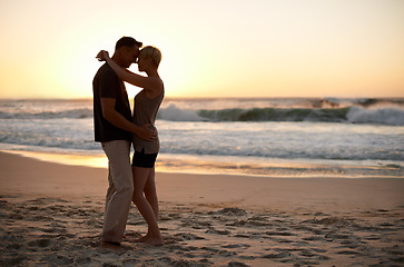 Image showing Couple, together and romance at sunset in ocean for peace in trip and vacation. Partners, embrace and relax in sea with water to enjoy, calm and smile for love of marriage in honeymoon and holiday