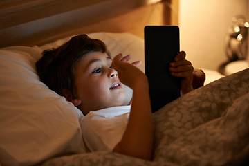 Image showing Boy, tablet and bed with night, digital and technology for social media or learning. Child, bedroom and connectivity for knowledge, youth and elearning or internet surfing at home with touchscreen