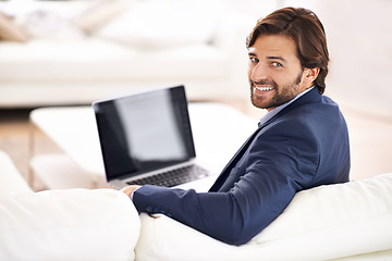Image showing Business, man and smile in living room with laptop on couch, remote work and small business with confidence in suit. Sofa, lounge and professional with online for information, startup and happy