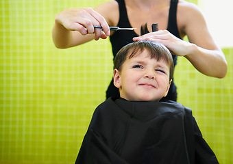 Image showing Child, boy and barber with haircut at salon for grooming, hairstyle and unhappy with scissors. Hairdresser, person and kid for hair treatment, haircare and hairdressing with comb or sitting on mockup