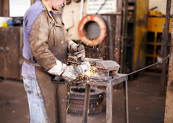 Image showing Blacksmith, man and grinder for metal with sparks, design or industry for metallurgy in factory. Person, worker or small business owner with power tools, steel or iron with manufacturing in warehouse