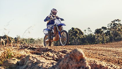 Image showing Stunt, race and man on dirt bike in desert with adventure, adrenaline and speed in competition, Extreme sport, trick and athlete on off road motorcycle for challenge, power or danger on action course